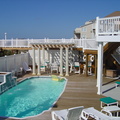 Pergola with fiberglass columns, vinyl railing and privacy fence with lattice, solar and low voltage lights